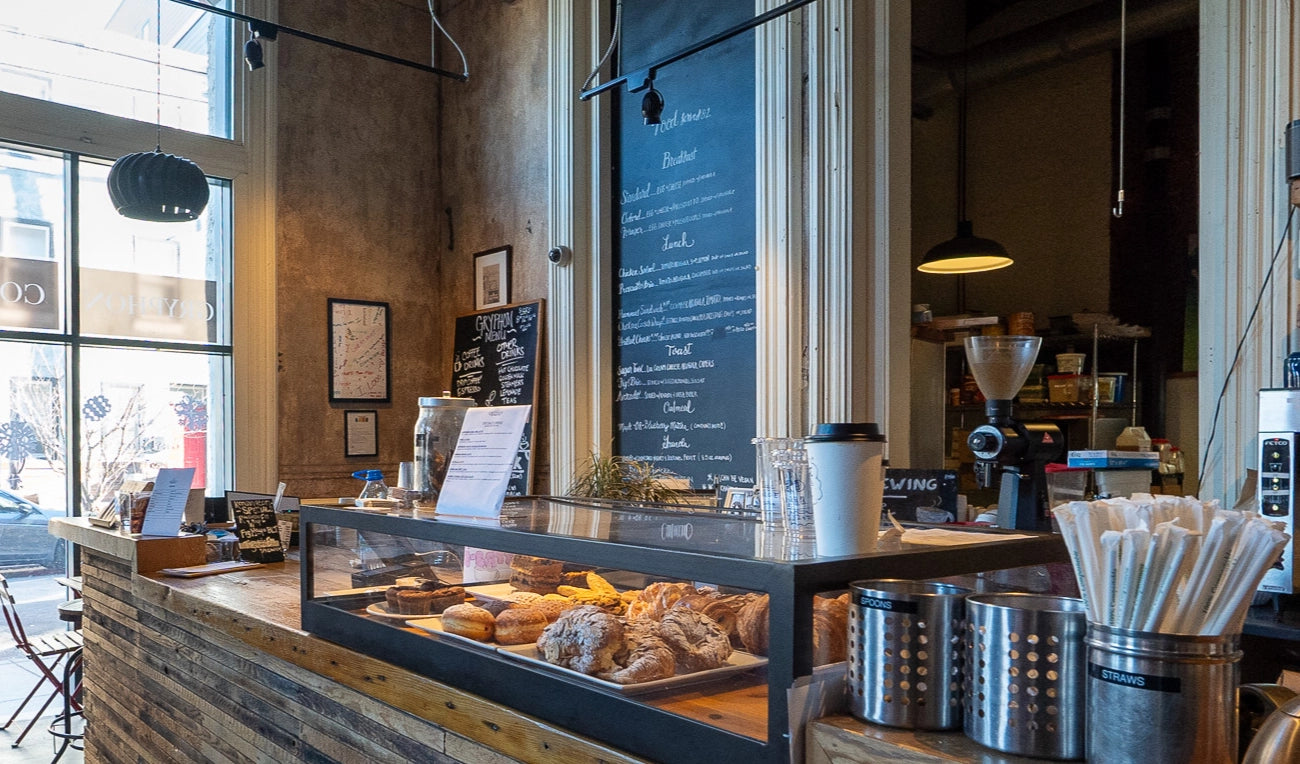 A sunny window above a wood counter with pastries at Gryphon in Kensington.
