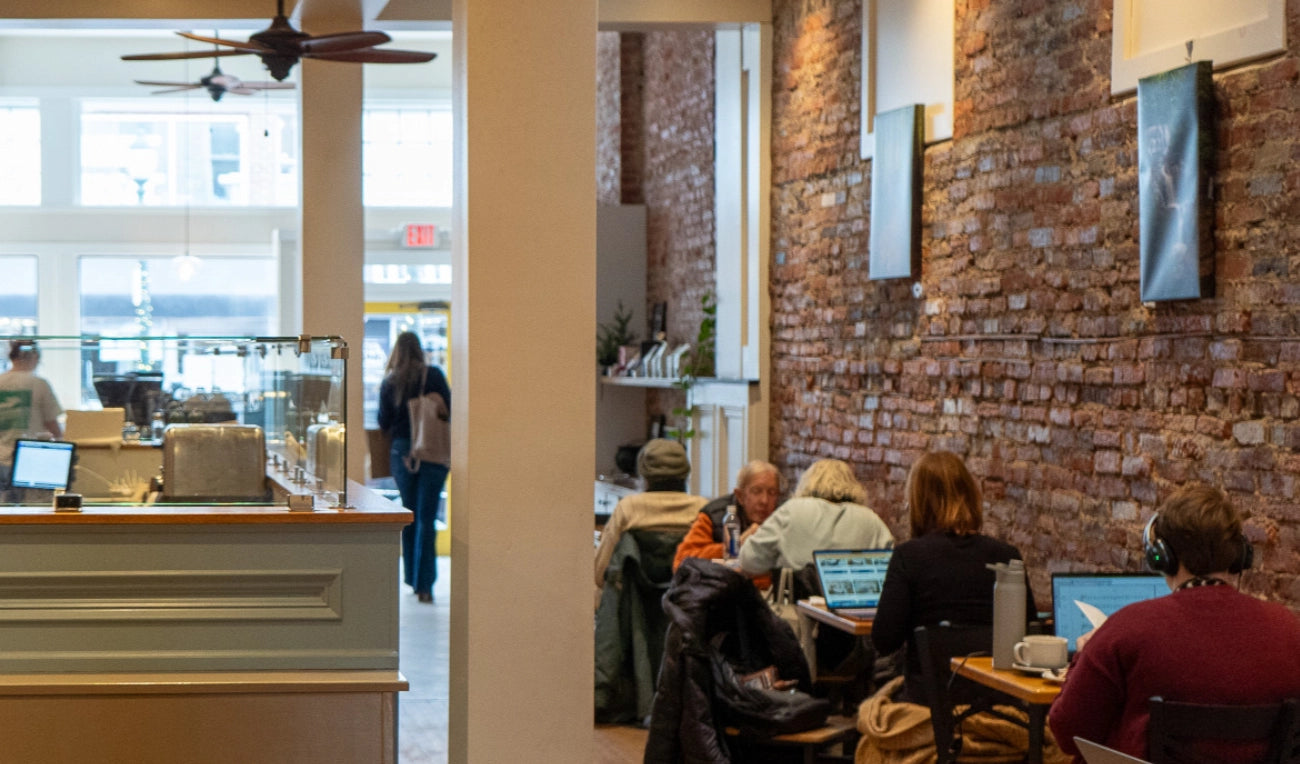 Interior of Gryphon Cafe in West Chester  with brick walls and people working.